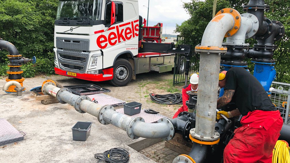Twee monteurs van Eekels sluiten een tijdelijke pompinstallatie aan voor een rioolbypass