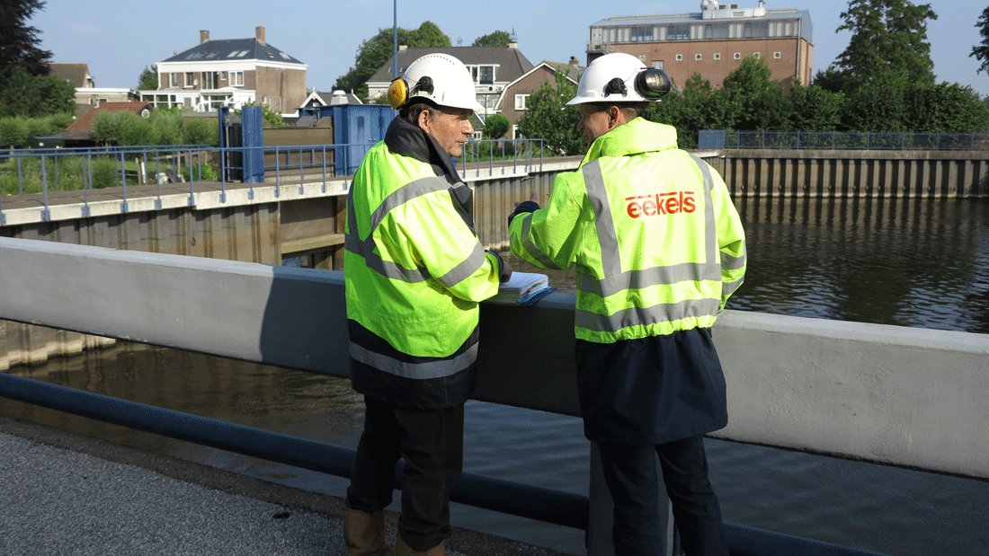 Pompmonteurs van Eekels Pompen bespreken een project op locatie aan het water