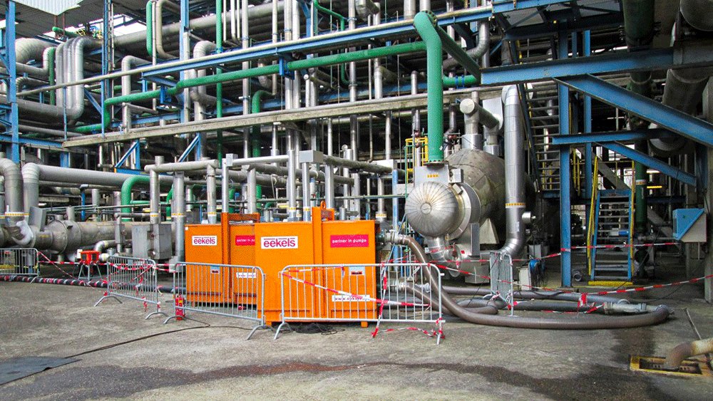 Oranje ATEX-pompen bij een industrieel bedrijf voeren een rioolbypass uit.