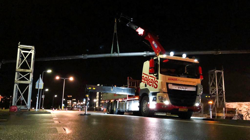 Vrachtwagen van Eekels' transportdienst hijst leidingbrug boven wegdek in Zwijndrecht