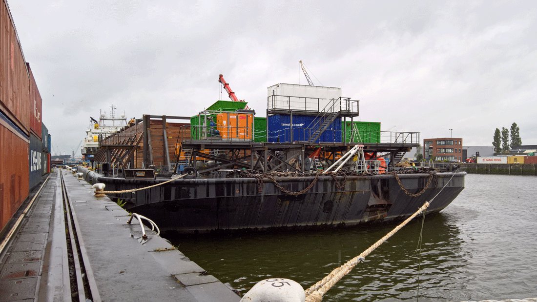 Een grote loadout-ponton met zware containers er op