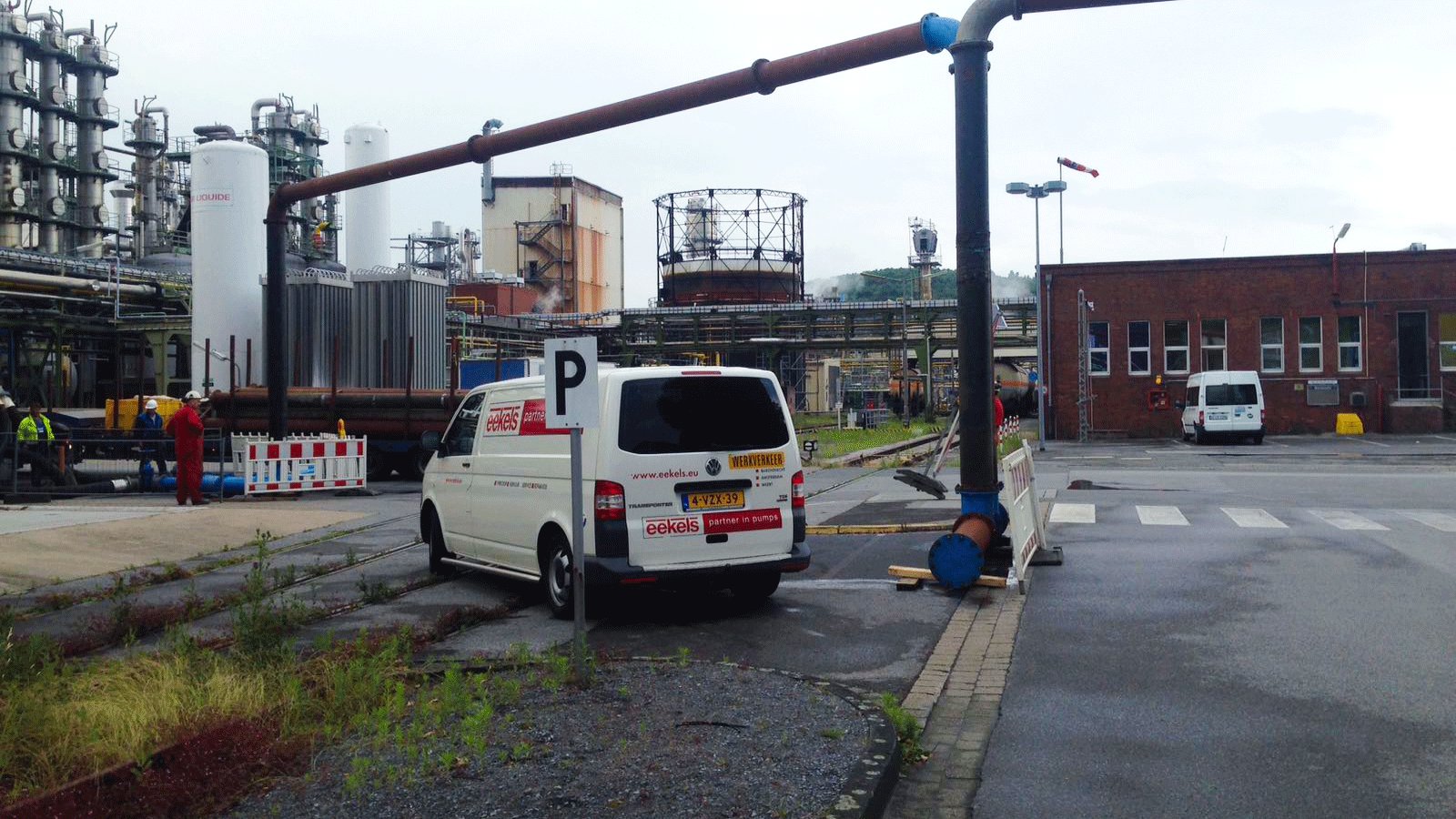 Een Eekels Pompen servicewagen staat op locatie bij een industrieproject met tijdelijk leidingwerk.